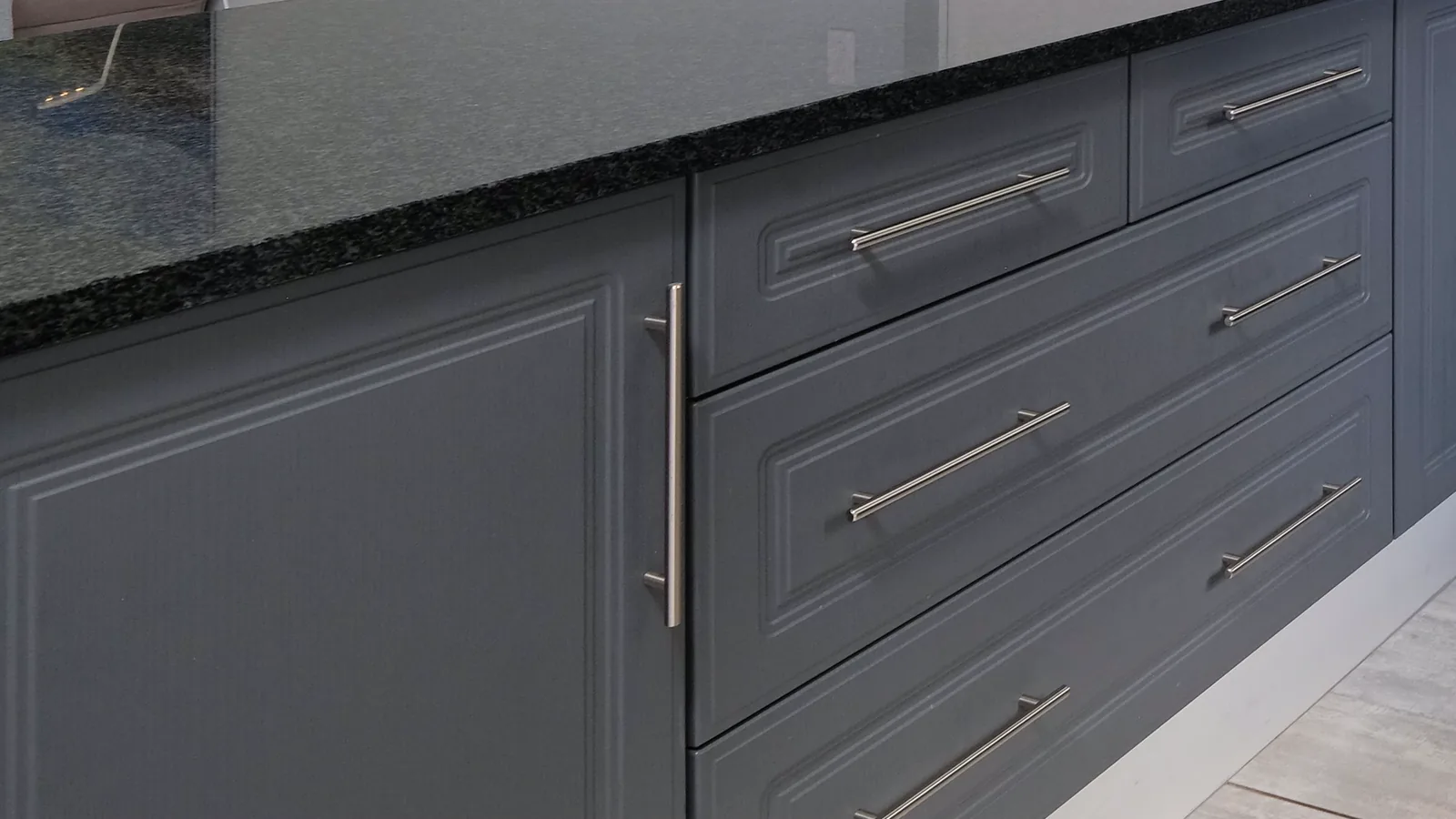 Grey painted cabinet doors and drawers with raised-panel profiles