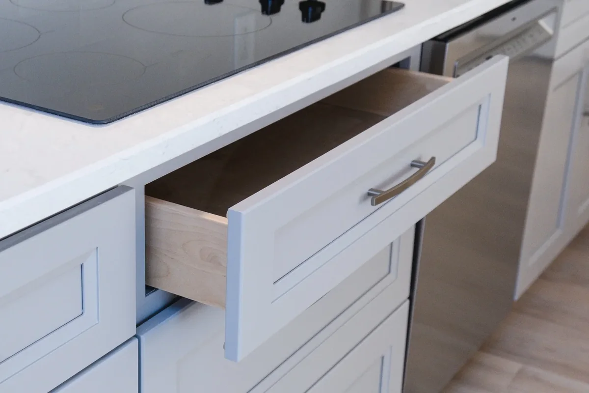 Open wood drawer box fitted between finished cabinet fronts